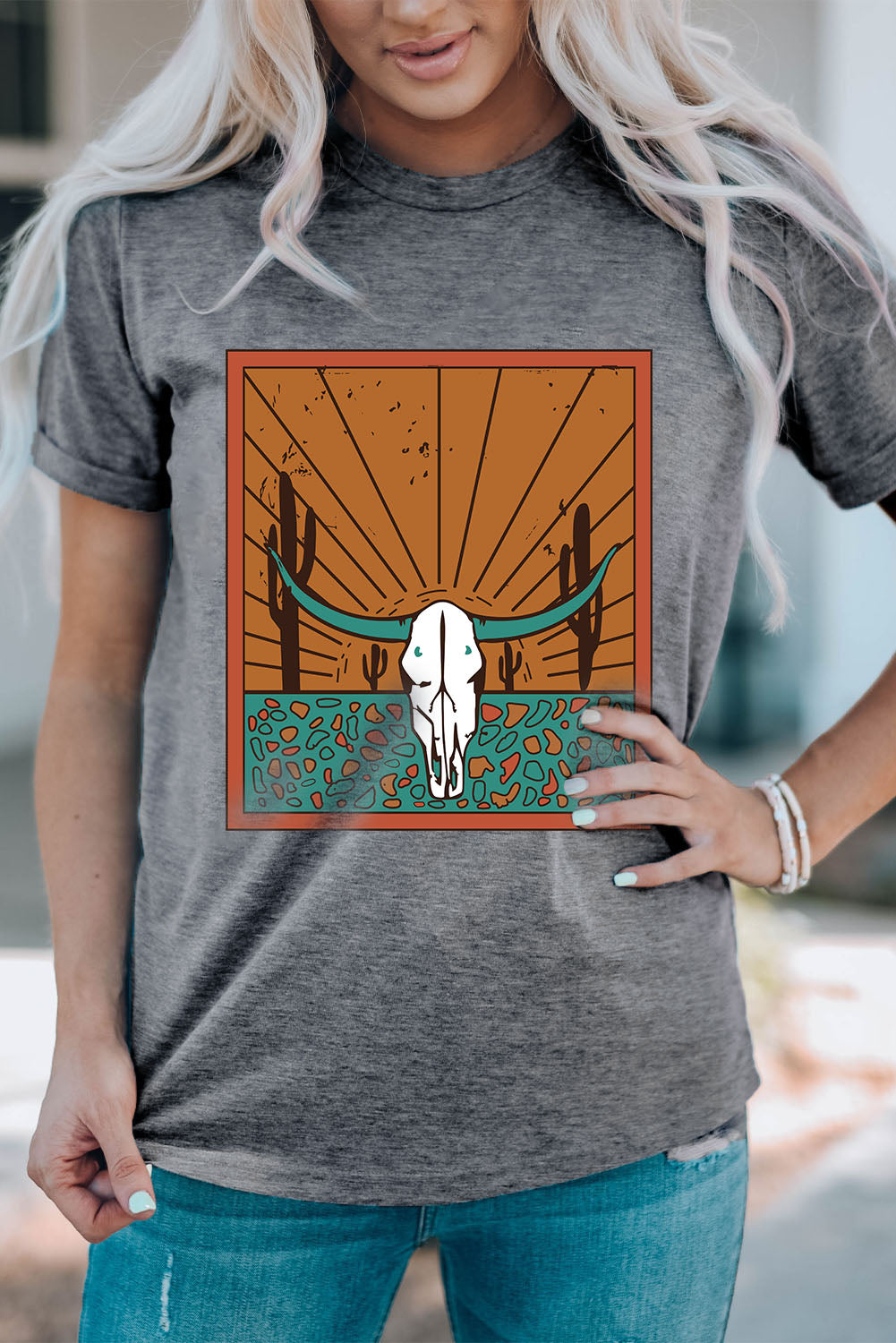 bold cow skull graphic on a gray round necked tshirt with orange and turquoise and cactus details